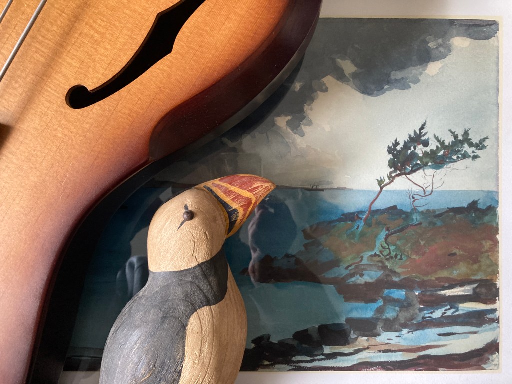 still life with puffin bird carving, bass guitar f-hole, and Winslow Homer watercolor